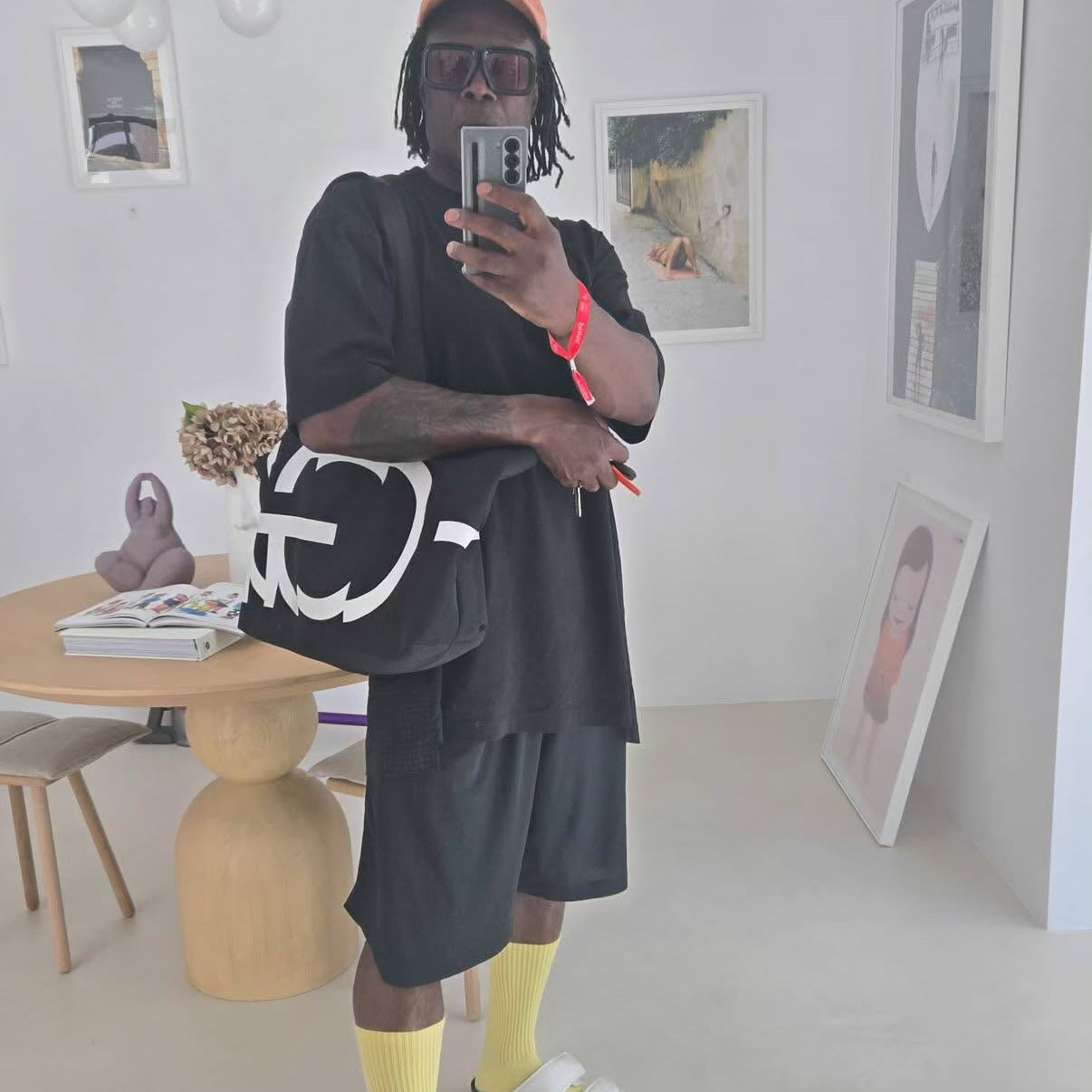 Person taking a mirror selfie in a modern room with minimal decor.