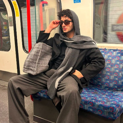 Person sitting on a subway train with a patterned seat