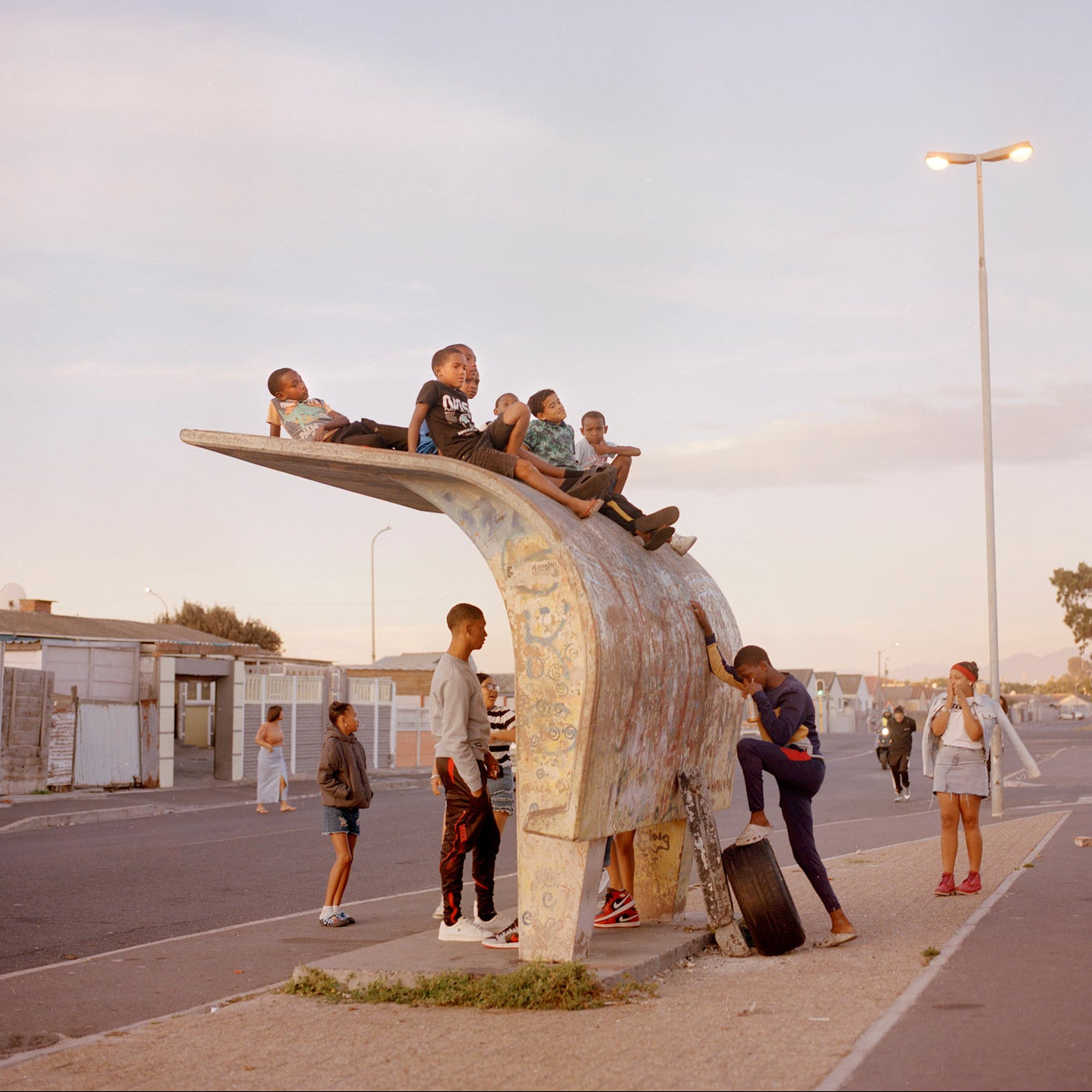 Children playing on a large metal sculpture in an urban setting