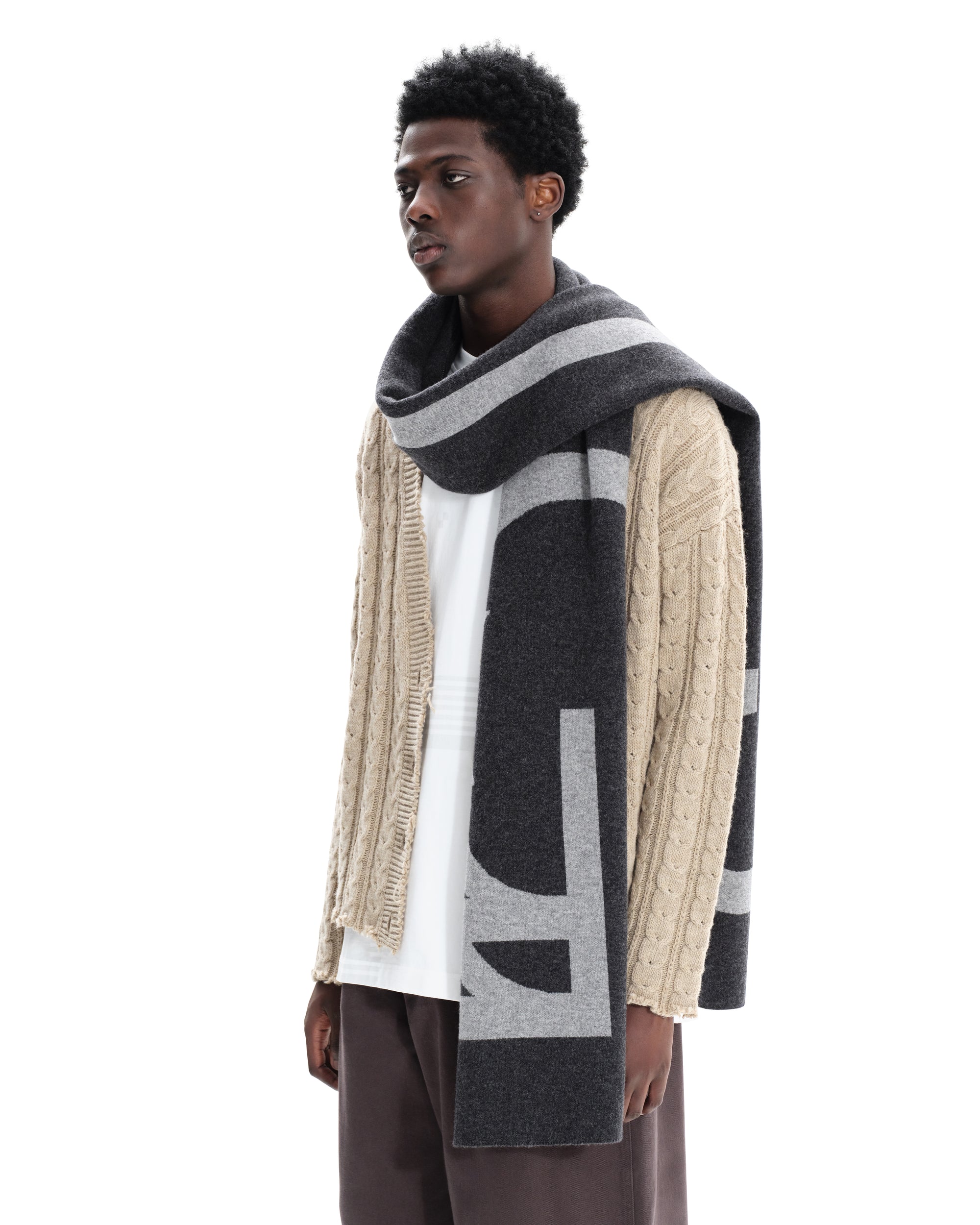 Model with grey English made SustainaWOOL certified scarf wrapped around neck, demonstrating versatile wear.