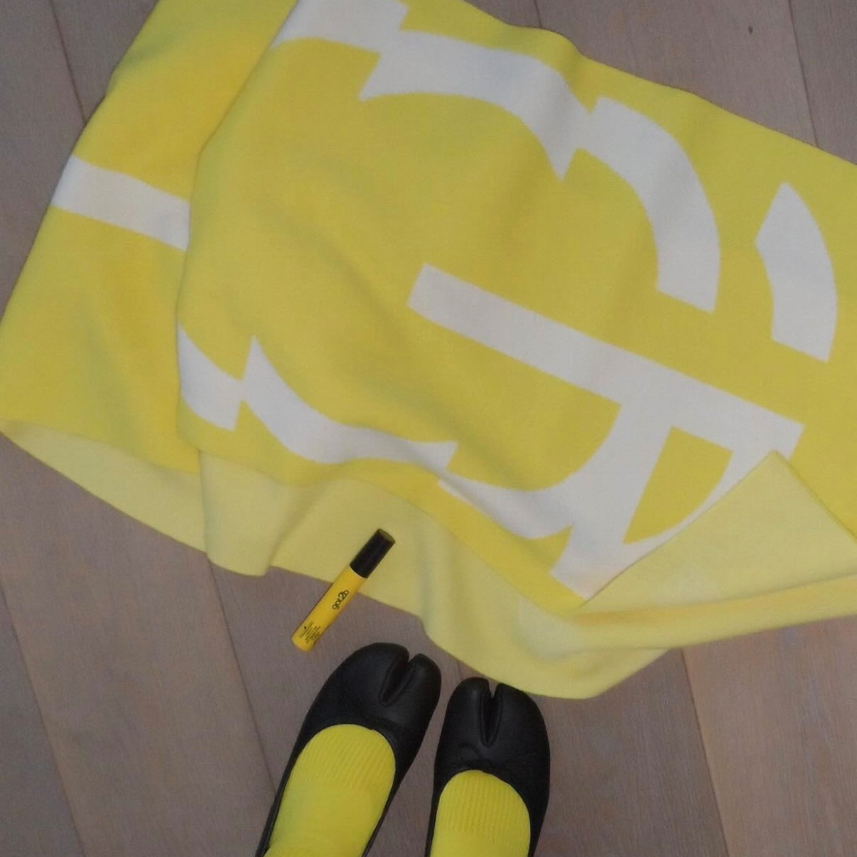 Yellow  scarf with a logo on a wooden floor