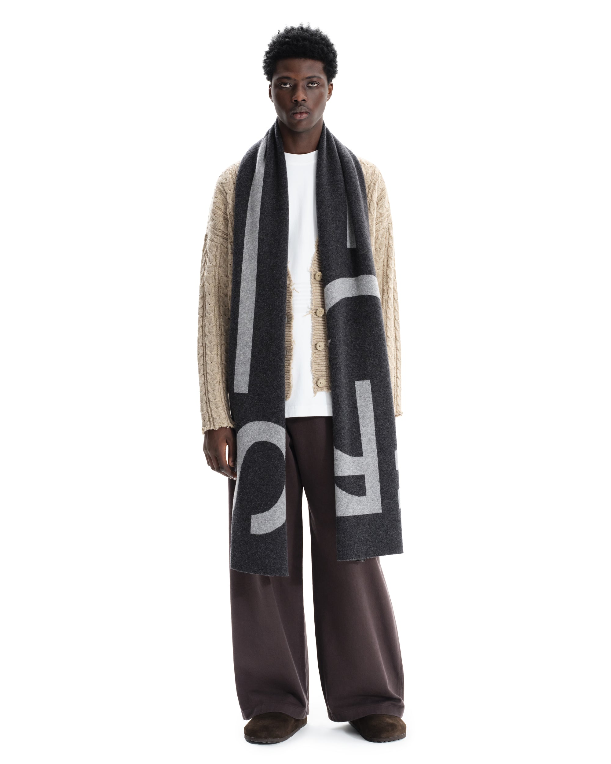 Male model wearing extra large grey marl merino wool scarf draped long, displaying full length. Made in England.